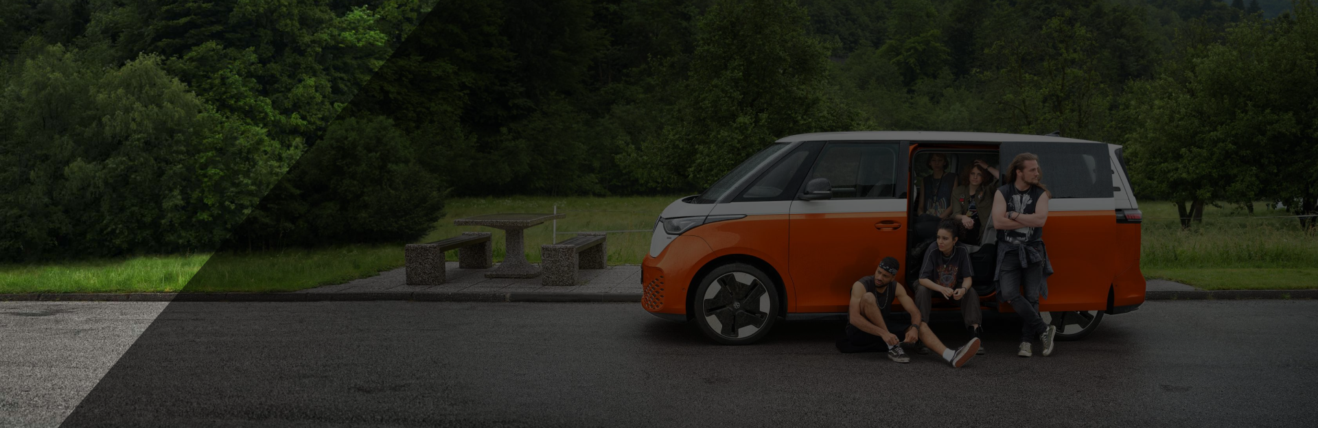 Grupper junger Menschen vor einem orange-gelben VW ID BUZZ