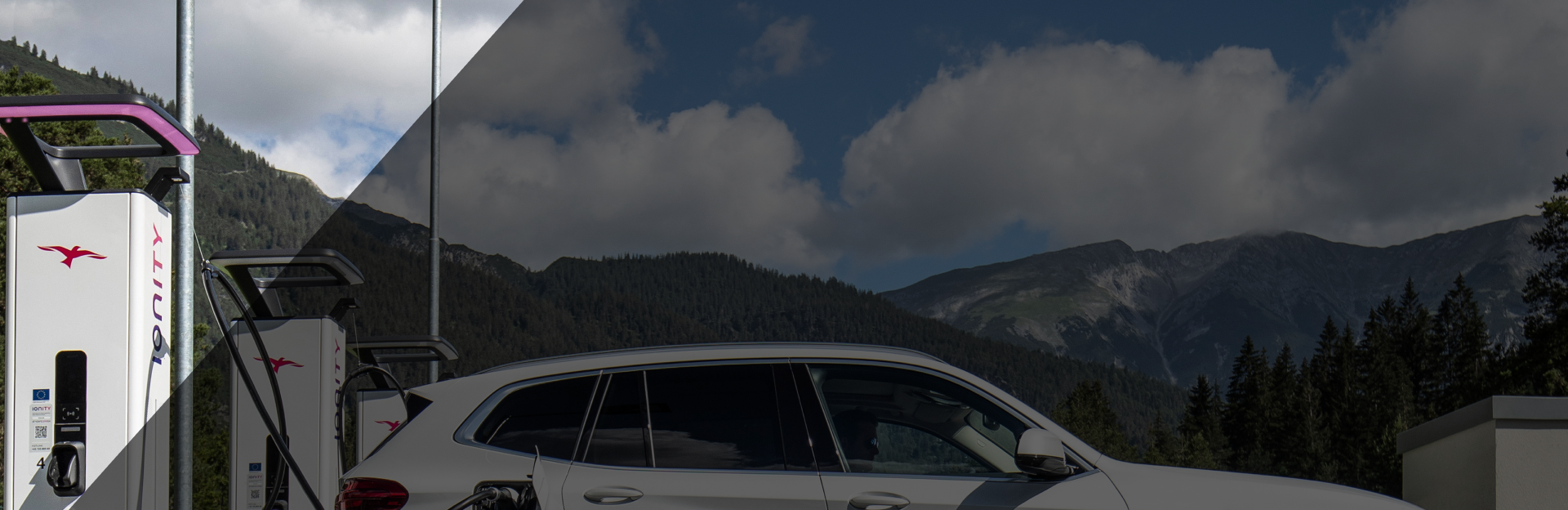 Weißer BMW_ix3 lädt an einer IONITY Ladesäule vor einem Bergpanorama