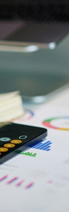 Image détaillée d'un bureau avec calculatrice et graphiques.