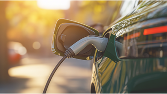 Un'auto elettrica verde con la presa di ricarica in fase di ricarica.