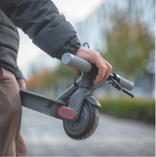 Een man houdt een opgevouwen elektrische step in zijn handen.