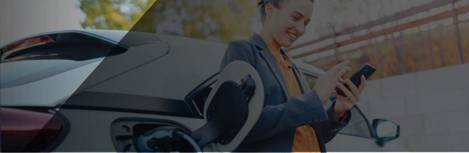 Een vrouw leunt tegen haar witte elektrische auto terwijl ze tankt. Ze kijkt tevreden naar haar mobiele telefoon, want ze laadt op tegen een voordelig elektriciteitstarief van Rabot Energy.